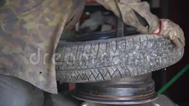 由机械师修理汽车爆胎. 在换胎器的帮助下，从合金车轮上取出轮胎的过程